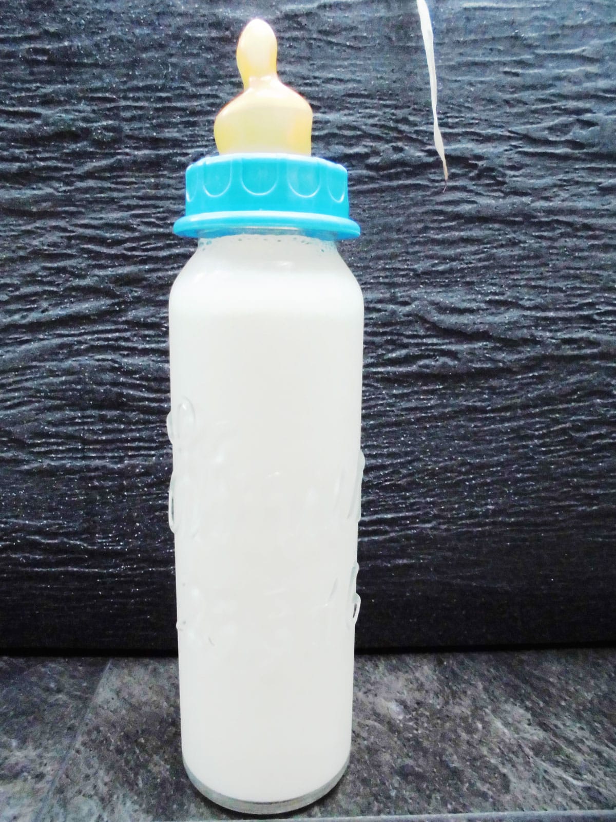 Babyflasche mit Namen mit Milch gefüllt in glasklarer Schrift