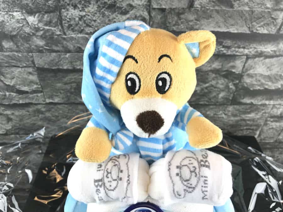 Der Teddybär steuert das Windelmotorrad über die aus Baby-Söckchen bestehende Lenkstange